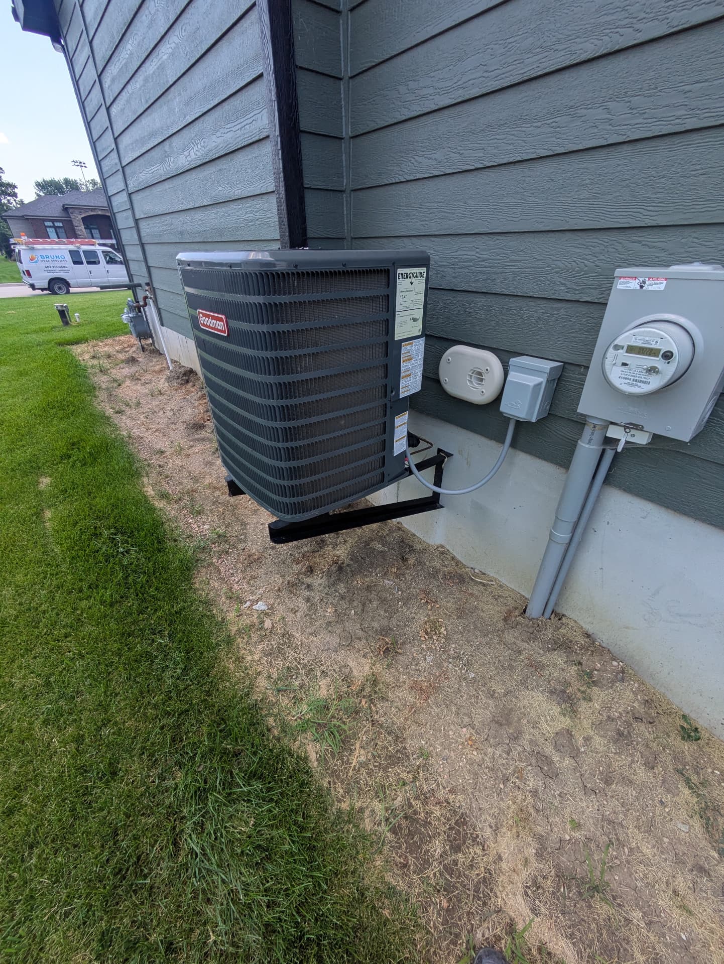 Completed Goodman outdoor air conditioner installation beside a home